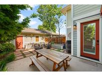 Private backyard features a patio with wood picnic table, chairs, planters and lush landscaping at 1265 S Sherman St, Denver, CO 80210