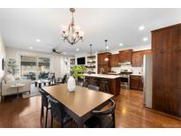 Bright, open-concept living room and kitchen with hardwood floors and stainless steel appliances at 1265 S Sherman St, Denver, CO 80210