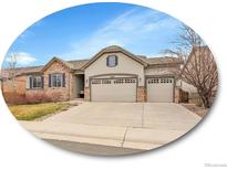 Charming home featuring a three-car garage, stone accents, and neutral stucco exterior at 10770 Hillrose St, Parker, CO 80134