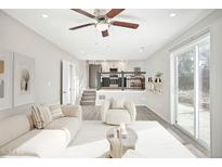 Bright, inviting living room with modern furnishings, ceiling fan, and sliding glass doors at 3408 S Olathe Way, Aurora, CO 80013