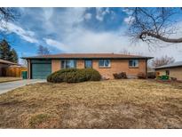 Charming single-story brick home with well-maintained landscaping and an attached garage at 12235 E Kentucky Ave, Aurora, CO 80012