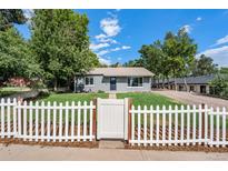 Charming gray house with white picket fence and landscaped lawn at 3100 Gray St, Denver, CO 80214