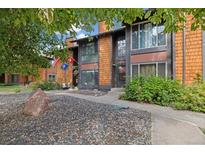 Townhouse exterior features wood siding, stone landscaping, and mature trees at 1231 S Crystal Way, Aurora, CO 80012
