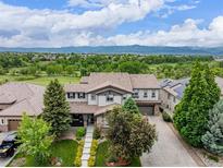 Beautiful two-story home with lush landscaping, a well-manicured lawn, and mountain views at 8993 Stonecrest Way, Highlands Ranch, CO 80129