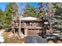 Mountain home exterior with a two-car garage and balcony at 1228 Pomegranate Ln, Golden, CO 80401