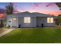 Charming single-story home with a well-manicured lawn and inviting front entrance at dusk at 903 Poplar St, Denver, CO 80220