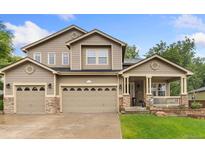 Charming two-story home featuring a three-car garage and inviting front porch with stone accents at 1831 Ashford Cir, Longmont, CO 80504