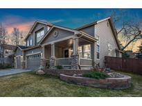 Charming two-story home with a covered front porch and well-maintained front yard and a two car garage at 1831 Ashford Cir, Longmont, CO 80504