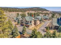 Scenic mountain neighborhood featuring townhomes with mature trees and convenient garages at 1294 Red Lodge Dr, Evergreen, CO 80439