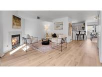 Bright living room boasts a fireplace, modern furniture, and lots of natural light at 1330 S Monaco Pkwy # 2, Denver, CO 80224