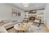 Bright living room featuring a brick fireplace, built-in bookshelves, and stylish furniture at 5080 S Boston St, Greenwood Village, CO 80111
