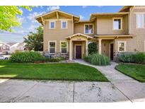 Charming tan two-story home with well-manicured lawn and stone accents at 10480 Truckee St # B, Commerce City, CO 80022