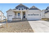Charming home with a covered porch, white pillars, well-kept landscaping, and a two-car garage at 39450 Congress Ln, Elizabeth, CO 80107