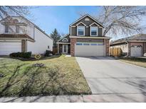 Charming two-story home featuring a two-car garage and well-manicured lawn on a sunny day at 5609 S Youngfield Way, Littleton, CO 80127