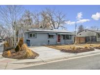 Charming single-story home with a well-maintained lawn, solar panels, and a paved driveway at 3930 S Hazel Ct, Englewood, CO 80110