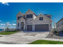 Beautiful two-story home with a stone facade, three gables, and a spacious three-car garage at 6860 S Yantley Ct, Aurora, CO 80016
