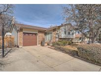 Charming split-level home featuring a brick facade, two-car garage, and well-maintained landscaping at 15341 E Arkansas Pl, Aurora, CO 80017