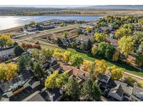 A beautiful aerial view of townhomes showcases vibrant fall foliage near a serene lake and community at 5374 W Canyon Trl # B, Littleton, CO 80128