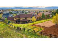 Expansive backyard with lush green grass, a wooden fence and mountain views in the background, offering a serene and private retreat at 3048 Starling Ct, Castle Rock, CO 80109