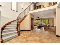 Elegant foyer with a grand staircase, iron railings, high ceilings, and an open view to the living room, creating a welcoming ambiance at 3048 Starling Ct, Castle Rock, CO 80109