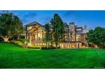 Stunning home exterior with a beautiful lawn, large windows, and stone accents at 5 Random Rd, Cherry Hills Village, CO 80113