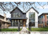 Beautiful two-story home with modern design, black trim, a manicured lawn, and a black metal fence at 754 S York St, Denver, CO 80209