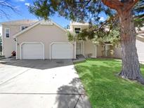 Charming home featuring a two-car garage, well-manicured lawn, and mature trees at 389 S Kalispell Way # C, Aurora, CO 80017