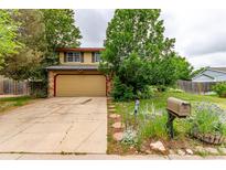 Charming two-story home with tan siding, brick accents, and a well-maintained front yard at 18206 E Loyola Dr, Aurora, CO 80013