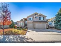 Two-story house with a three-car garage and landscaped yard at 678 Kryptonite Dr, Castle Rock, CO 80108