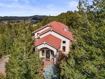 Stunning home with red tile roof nestled in the trees, offering scenic views at 1425 Autumnwood Ln, Evergreen, CO 80439