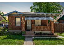 Charming brick home with a covered front porch and well-maintained lawn at 2564 S Acoma St, Denver, CO 80223