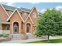 Charming townhome featuring an inviting entrance, complemented by lush greenery and beautiful architectural details at 18173 E Saskatoon Pl, Parker, CO 80134