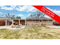 Spacious backyard with a patio, fire pit, and covered outdoor area, perfect for entertaining at 1823 S Carr St, Lakewood, CO 80232