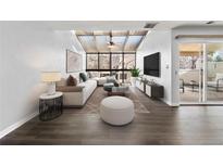 Bright living room featuring vaulted ceilings with skylights, hardwood floors, and modern furnishings at 2314 S Troy St, Aurora, CO 80014