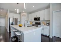 Bright, open kitchen with stainless steel appliances, center island, and breakfast bar at 4238 S Netherland Cir, Aurora, CO 80013