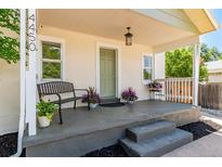 Inviting front porch with bench seating and decorative plants, perfect for enjoying the outdoors at 4450 S Fox St, Englewood, CO 80110