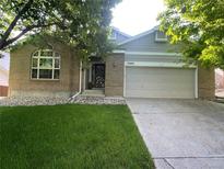 Charming brick home with a well-maintained lawn and attached two-car garage at 13660 Monroe St, Thornton, CO 80602