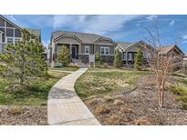 Charming one-story home featuring a landscaped front yard and a winding concrete walkway at 1104 Brocade Dr, Littleton, CO 80126