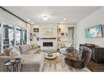 Bright living room with a cozy fireplace, comfortable seating, and access to outdoor patio at 1104 Brocade Dr, Littleton, CO 80126
