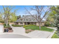 Charming single-Gathering home featuring a well-manicured front yard with a circular driveway and a welcoming porch at 2500 Van Gordon St, Lakewood, CO 80215