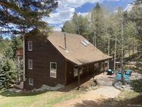 Inviting two-story home with warm wood siding, skylights, and an expansive patio area at 11724 Little Turtle Ln, Conifer, CO 80433