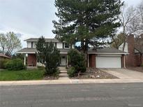 Charming two-story home with brick and white siding, a well-manicured lawn, and mature trees at 7970 S Cook Way, Centennial, CO 80122
