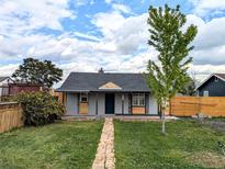 Charming single-story home with a well-maintained front yard and inviting brick pathway at 6608 Hooker St, Denver, CO 80221