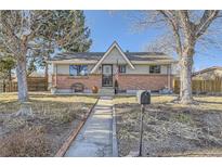 Charming single-Gathering home featuring a brick facade, manicured lawn, and walkway leading to the front door at 791 S Routt Way, Lakewood, CO 80226