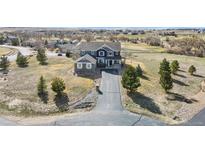 Charming home boasts a long driveway and a landscaped front yard, complementing its blue siding at 5285 La Quinta Cir, Elizabeth, CO 80107