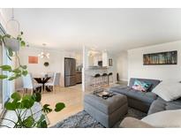 Bright living room features hardwood floors, neutral decor, and easy access to the kitchen and dining areas at 1350 Josephine St # 307, Denver, CO 80206
