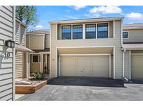 Two-story townhouse featuring a one-car garage, and neutral-colored siding against a blue sky at 1011 Pierce St # 11, Lakewood, CO 80214