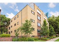 Multi-story brick apartment building with mature trees, garden, and landscaping at 10 N Ogden St # 5, Denver, CO 80218
