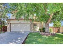 Inviting front exterior of home showcasing mature landscaping, brick accents, and a two-car garage at 15941 Bluebonnet Dr, Parker, CO 80134