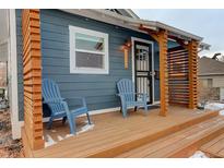 Charming front porch with blue Adirondack chairs, wooden deck and blue siding at 273 S Lowell Blvd, Denver, CO 80219